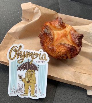 A kouign amann pastry and a sticker "Olympia coffee"
